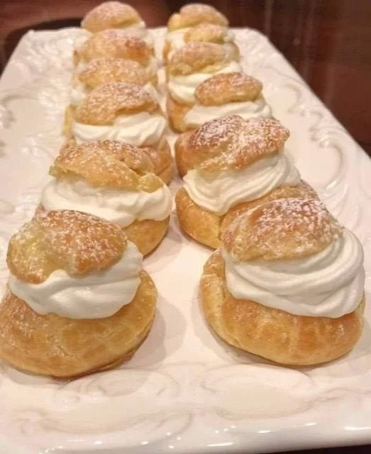 Delicious cream puffs filled with rich cream and topped with powdered sugar.
