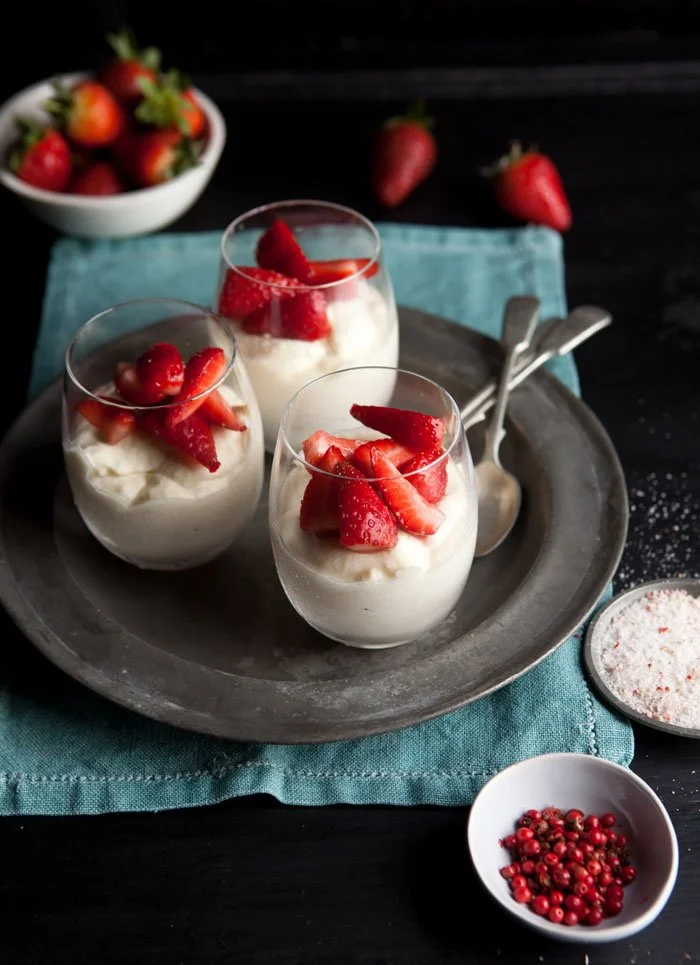 Strawberry-topped white chocolate mousse served in elegant bowls.