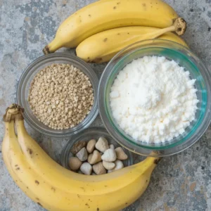 A loaf of freshly baked 4-ingredient banana bread sliced and displayed on a wooden cutting board, with ripe bananas and a knife in the background.