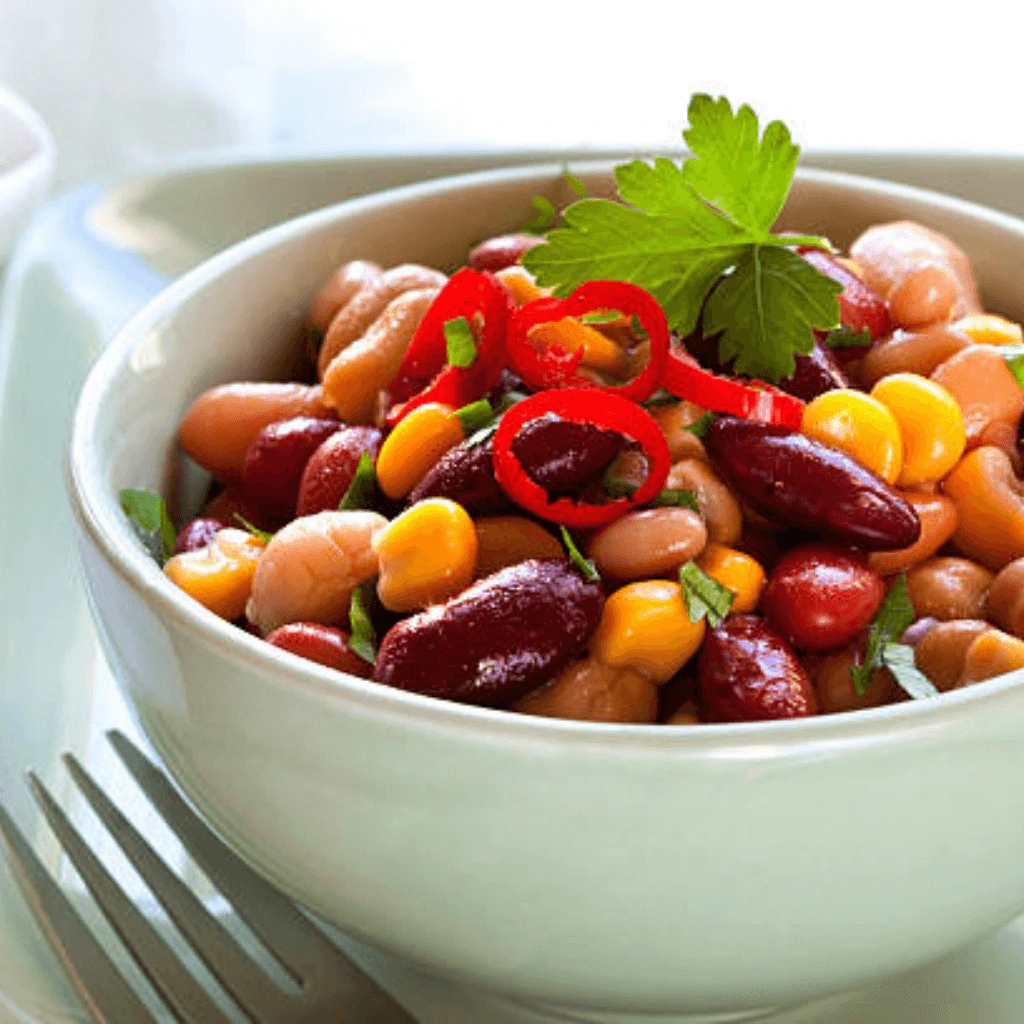 Colorful and nutritious dense bean salad with a variety of beans, fresh vegetables, and a tangy dressing