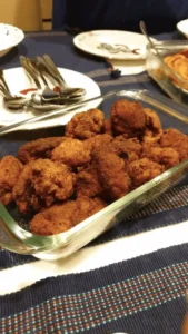 Golden crispy fried chicken from top New York City restaurants, including Southern-style, Korean-inspired, and halal options, served with dipping sauces and classic sides like coleslaw and cornbread.