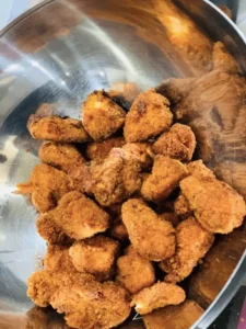 Golden crispy fried chicken from top New York City restaurants, featuring Southern-style, Korean-inspired, and halal options, served with dipping sauces and classic sides like coleslaw and cornbread.