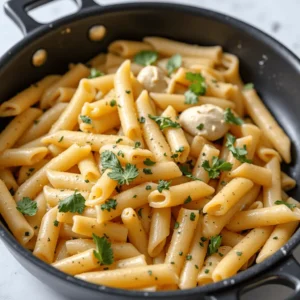 One skillet chicken pasta with creamy sauce, chicken, and vegetables in a pan