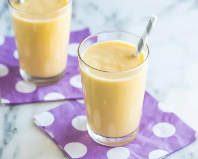 Delicious banana smoothie ingredients including banana, yogurt, and milk in a blender.