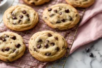 Freshly baked chewy chocolate chip cookies cooling on a rack