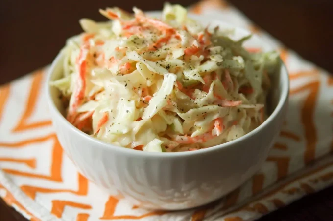 Bowl of best sweet coleslaw recipe with fresh vegetables and dressing