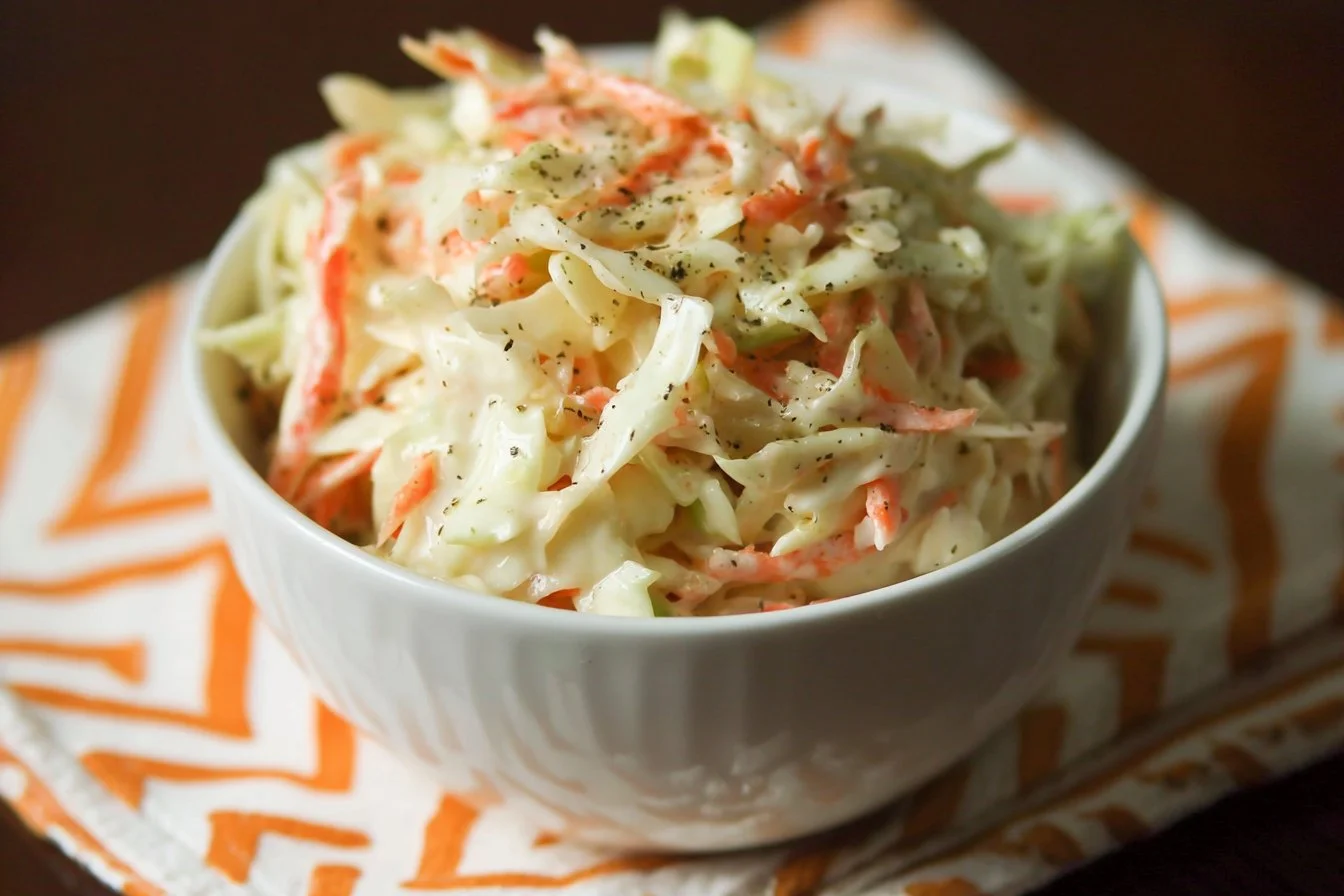 Bowl of best sweet coleslaw recipe with fresh vegetables and dressing