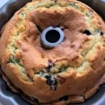 Slice of blueberry sour cream coffee cake with fresh blueberries on top