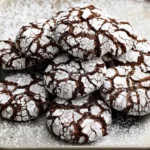 A plate of Chocolate Peppermint Crinkle Cookies dusted with powdered sugar.