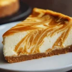 Creamy pumpkin swirl cheesecake topped with whipped cream and cinnamon