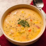 Bowl of creamy vegetable soup with fresh veggies and herbs