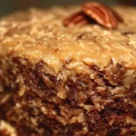 Homemade German Chocolate Cake garnished with coconut and pecan icing.