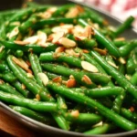 Plate of Green Beans Almondine topped with toasted almonds and lemon zest