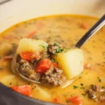 Bowl of Hamburger Potato Soup garnished with herbs and served hot.