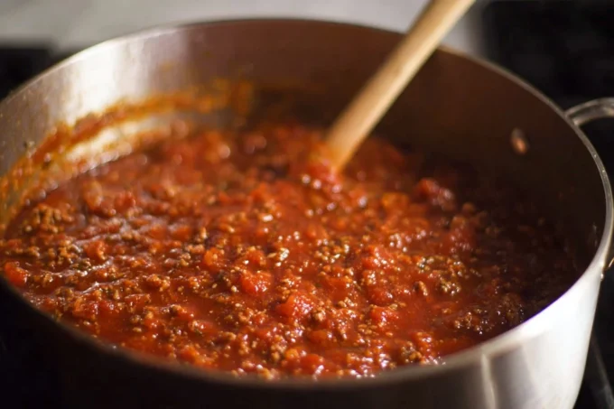 Bowl of homemade spaghetti sauce with fresh herbs and tomatoes