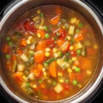 Bowl of healthy Instant Pot vegetable soup with fresh vegetables and herbs