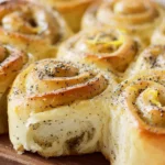 Freshly baked Lemon Poppy Seed Rolls on a wooden table.