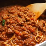 Homemade meat sauce served over pasta with fresh herbs