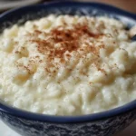 Delicious bowl of old fashioned rice pudding topped with cinnamon and raisins.