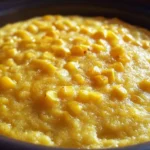 Slow Cooker Corn Pudding in a rustic ceramic dish