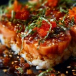 Spicy salmon sushi bake topped with avocado and green onions in a baking dish.