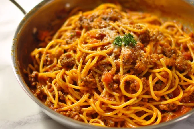 Bowl of taco spaghetti topped with cheese and cilantro