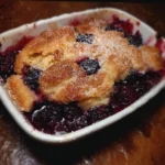 A warm blackberry cobbler served with a scoop of vanilla ice cream.