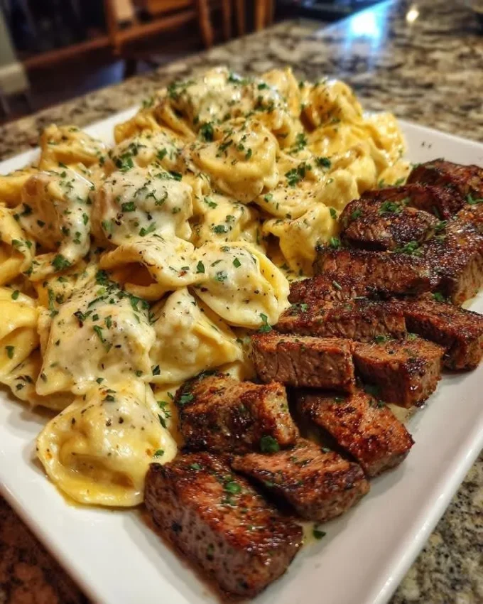 Delicious Cajun Garlic Butter Steak with Cheesy Alfredo Tortellini served on a plate.