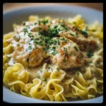 Plate of Chicken with Buttered Noodles garnished with herbs