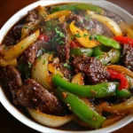 Chinese pepper steak with onions served on a plate