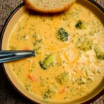 Delicious copycat Panera broccoli cheese soup served in a bowl with toppings.