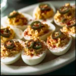 Delicious deviled eggs garnished with paprika on a white plate.