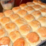 Freshly baked KFC biscuits on a plate, showcasing their flaky texture.