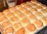 Freshly baked KFC biscuits on a plate, showcasing their flaky texture.