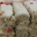 Delicious homemade banana cake topped with frosting and banana slices