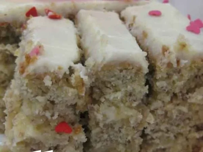 Delicious homemade banana cake topped with frosting and banana slices