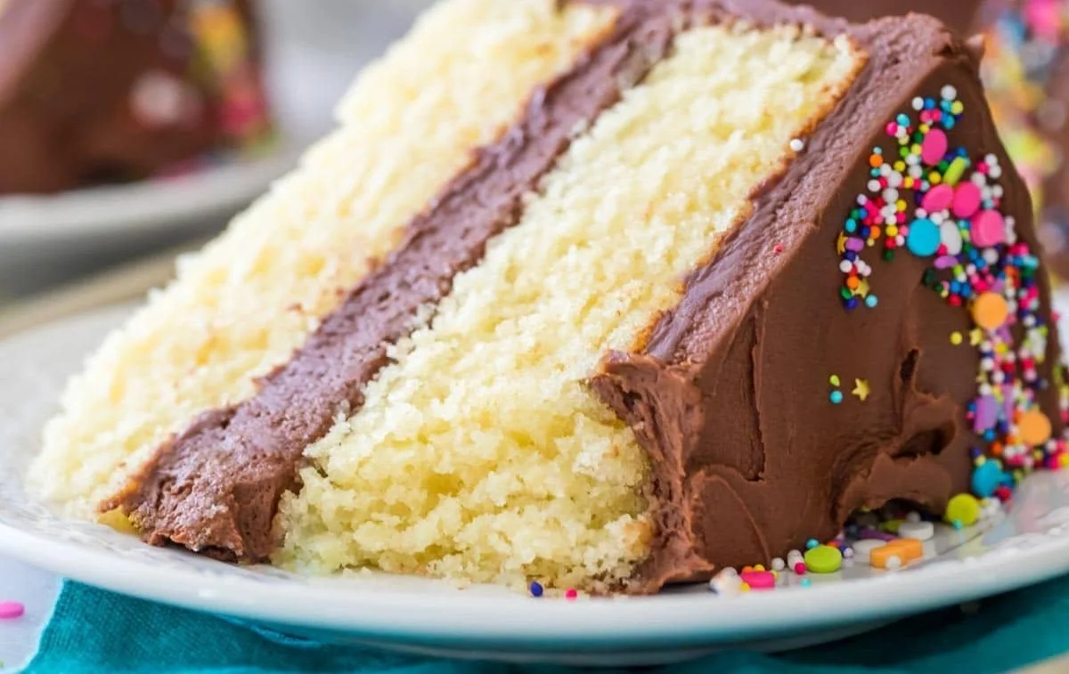 Delicious homemade vanilla cake topped with creamy frosting and fresh berries.