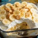 Delicious banana pudding served in a glass bowl with fresh bananas and whipped cream