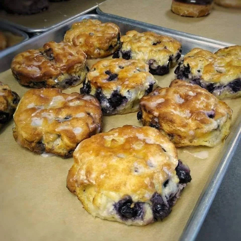A plate of golden-brown blueberry biscuits ready to be enjoyed.