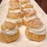 Delicious cream puffs filled with rich cream and topped with powdered sugar.