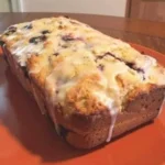 Sliced lemon blueberry bread on a wooden cutting board