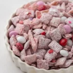 A bowl of tasty Muddy Buddies snack mix made with chocolate and peanut butter.