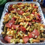 Colorful bowl of pasta salad with fresh vegetables and dressing