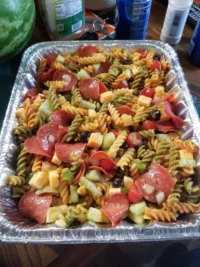 Colorful bowl of pasta salad with fresh vegetables and dressing