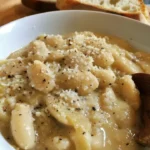 White Beans Cacio e Pepe Style dish served in a bowl with cheese and pepper