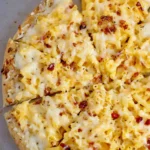Slice of Mac and Cheese Pizza topped with macaroni and melted cheese