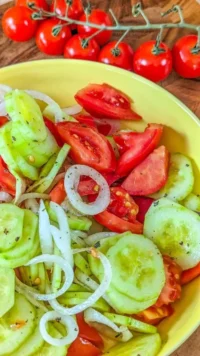 Delicious marinated cucumbers with onions and tomatoes in a bowl