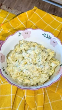 Bowl of Simple Southern Potato Salad garnished with parsley and eggs.
