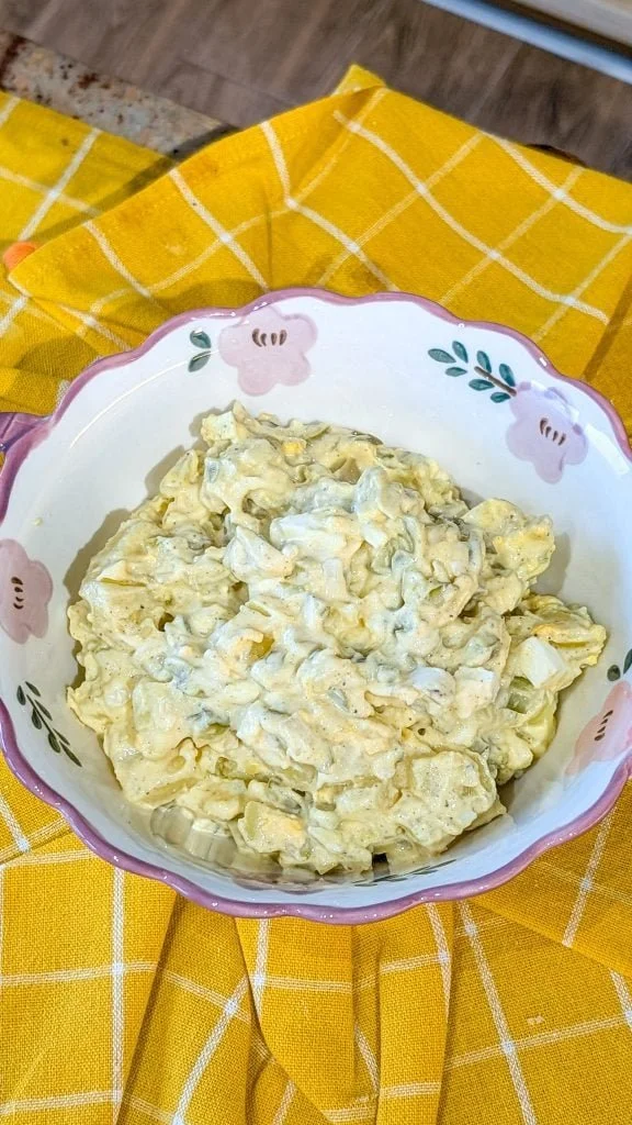 Bowl of Simple Southern Potato Salad garnished with parsley and eggs.