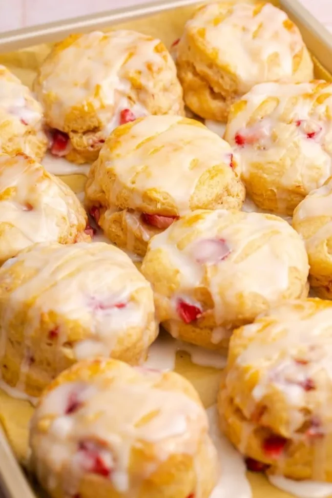 Freshly baked strawberry biscuits on a wooden table.